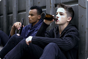 Two young men sitting on the ground drinking liquor - Matthew P. Kelley, Attorney at Law